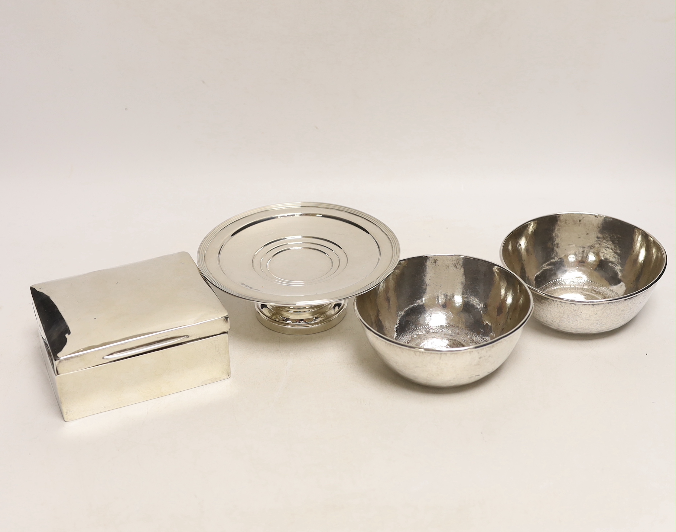 An Edwardian silver mounted cigarette box, London, 1901, 10.8cm, a small silver tazza and two continental white metal bowls, with inset coin bases.